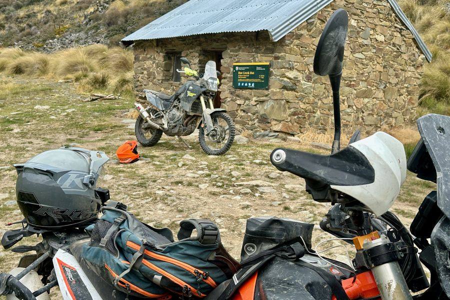 Adventure bikes parked at an old stone High Country hut