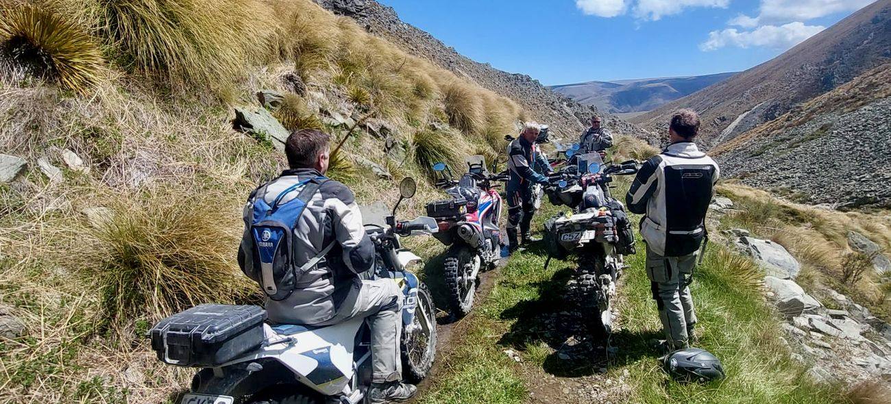 Adventure riders stopped together on a narrow High Country trail